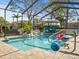 Inviting screened pool with waterfall feature, surrounded by lush landscaping at 14173 Pullman Dr, Spring Hill, FL 34609