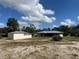 View of a house and detached shed from across the yard at 6114 Idle A While Cir, Dade City, FL 33523