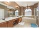 Elegant bathroom with double vanity, soaking tub and shower at 12923 Carlington Ln, Riverview, FL 33579