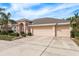 Two-story house with a three-car garage and palm trees in the front yard at 12923 Carlington Ln, Riverview, FL 33579