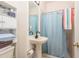 Simple bathroom with pedestal sink, shower, and storage at 12923 Carlington Ln, Riverview, FL 33579