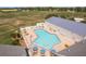Irregular shaped community pool with surrounding patio and tables at 12923 Carlington Ln, Riverview, FL 33579