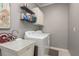 Laundry room with washer, dryer, utility sink, and storage shelves at 12923 Carlington Ln, Riverview, FL 33579