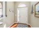 Bright entryway with hardwood floors, a white door, and nautical-themed decor at 12923 Carlington Ln, Riverview, FL 33579