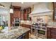 Gourmet kitchen featuring granite countertops, custom cabinets, and stainless steel appliances at 3341 Gulf Blvd, Belleair Beach, FL 33786