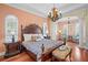 Luxurious main bedroom with detailed trim, hardwood floors, seating area and a decorative chandelier at 3341 Gulf Blvd, Belleair Beach, FL 33786