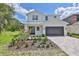 Two-story home with white siding, dark brown garage door, and landscaped front yard at 2919 W Elrod Ave, Tampa, FL 33611