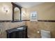 Elegant bathroom with dark vanity, granite countertop, and decorative mirror at 3341 Gulf Blvd, Belleair Beach, FL 33786