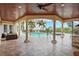 Resort-style pool and spa with covered patio, outdoor kitchen, and spiral staircase at 3341 Gulf Blvd, Belleair Beach, FL 33786
