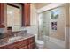Bathroom with a tub shower combo, granite countertop, and wooden cabinets at 3341 Gulf Blvd, Belleair Beach, FL 33786