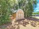Tan and green storage shed nestled in a wooded setting at 26240 Willow St, Brooksville, FL 34601