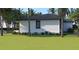 Rear view of a house showcasing a clean, white exterior and a spacious backyard at 4026 Yucatan Cir, Port Charlotte, FL 33948