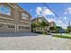 Tan three-story townhouses with two-car garages, paver driveways, and lush landscaping at 348 Larboard Way, Clearwater, FL 33767