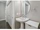 Small modern bathroom with pedestal sink and round mirror at 348 Larboard Way, Clearwater, FL 33767