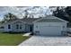 House exterior with stone accents, a two-car garage, and a gray roof at 37570 Teri Ct, Dade City, FL 33525