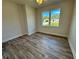 Bright bedroom with wood-look floors and a large window at 37570 Teri Ct, Dade City, FL 33525