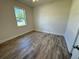 Well-lit bedroom, featuring wood-look floors and a window with a view at 37570 Teri Ct, Dade City, FL 33525