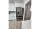 Stainless steel refrigerator in a kitchen with white cabinets and wood-look flooring at 37570 Teri Ct, Dade City, FL 33525
