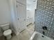 Bathroom with toilet, double vanity, and patterned tile at 37570 Teri Ct, Dade City, FL 33525