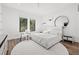 Airy bedroom with hardwood floors, two windows, and a round rug under the bed at 103 5Th N Ave, St Petersburg, FL 33701