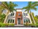 Modern home with wood and white facade, palm trees, manicured landscaping, and black fence at 103 5Th N Ave, St Petersburg, FL 33701