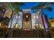 Night view of a modern home with palm trees, manicured landscaping, and black fence at 103 5Th N Ave, St Petersburg, FL 33701