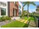 Modern home featuring an artificial turf lawn with stone walkways, lush landscaping, and a wood facade at 103 5Th N Ave, St Petersburg, FL 33701