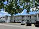 White two-story apartment complex featuring car parking, trimmed shrubs, and balcony access at 304 46Th Avenue W Ter # 218, Bradenton, FL 34207