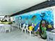 Undercover patio area with mural and seating near the pool at 304 46Th Avenue W Ter # 218, Bradenton, FL 34207