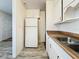 Efficient kitchen with white cabinets and wood-look countertops at 1318 Preston S St, St Petersburg, FL 33712