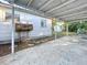 Backyard with covered patio, rusty barrel smoker, and small shed at 1318 Preston S St, St Petersburg, FL 33712
