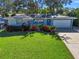 Attractive light blue house with a well-manicured lawn and solar panels at 1265 Magnolia Dr, Clearwater, FL 33756