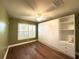 Bright bedroom featuring hardwood floors, plantation shutters, built in wardrobe and plenty of natural light at 15810 Cobble Mill Dr, Wimauma, FL 33598