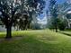 Expansive lawn and mature trees create a serene and private backyard setting for the home at 168 Rue Des Chateaux, Tarpon Springs, FL 34688