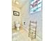 Bright bathroom features tiled floors, textured walls, toilet, and decorative shelving at 168 Rue Des Chateaux, Tarpon Springs, FL 34688