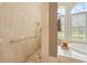 Tiled walk-in shower and garden tub with plantation shutters create a spa-like bathroom at 168 Rue Des Chateaux, Tarpon Springs, FL 34688