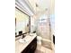 Beautiful bathroom with a glass shower, neutral tile, a single sink, and a large framed mirror at 168 Rue Des Chateaux, Tarpon Springs, FL 34688