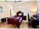 Bedroom features dark wood furniture, ceiling fan, and wood grain flooring at 168 Rue Des Chateaux, Tarpon Springs, FL 34688