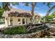 Community entrance with stone facade, manicured landscaping, and neighborhood signage under a sunny sky at 168 Rue Des Chateaux, Tarpon Springs, FL 34688