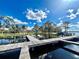Picturesque view of a dock extending over calm water, reflecting a blue sky with puffy white clouds at 168 Rue Des Chateaux, Tarpon Springs, FL 34688
