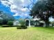 Attractive single-story home with large lawn, lush landscaping, and partly cloudy sky at 168 Rue Des Chateaux, Tarpon Springs, FL 34688