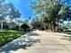 Home exterior with a long driveway, a basketball hoop, and mature trees providing a picturesque setting at 168 Rue Des Chateaux, Tarpon Springs, FL 34688