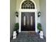 Elegant front door with decorative glass, sidelights, and manicured greenery enhance the home's curb appeal at 168 Rue Des Chateaux, Tarpon Springs, FL 34688