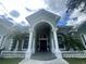 Grand entrance with elegant columns, arched doorway, and meticulously landscaped surroundings at 168 Rue Des Chateaux, Tarpon Springs, FL 34688