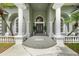 Grand home entrance with stately columns, manicured plants, and decorative accents at 168 Rue Des Chateaux, Tarpon Springs, FL 34688