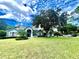 Charming single-story home with a well-manicured lawn and lush landscaping under a blue sky at 168 Rue Des Chateaux, Tarpon Springs, FL 34688