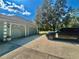 Attached two-car garage, complemented by a black car in the driveway, under a bright sky at 168 Rue Des Chateaux, Tarpon Springs, FL 34688