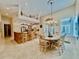 Dining area showcasing an open kitchen, bar seating, and elegant chandelier at 168 Rue Des Chateaux, Tarpon Springs, FL 34688