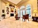 Bright living room with a cozy fireplace, custom built-ins, and arched windows overlooking the pool area at 168 Rue Des Chateaux, Tarpon Springs, FL 34688