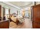 Elegant main bedroom with tray ceiling, wood floors, sitting area, and decorative arch windows at 168 Rue Des Chateaux, Tarpon Springs, FL 34688